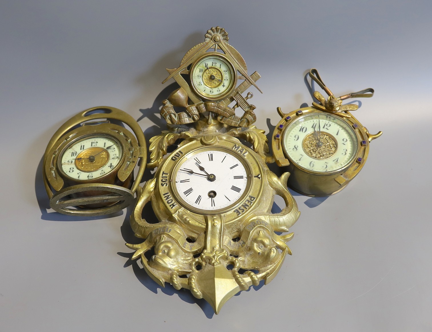 Two Edwardian brass horseshoe desk timepieces, one cast with fox head and folded crops, together with a smaller brass desk timepiece and one other, tallest 17cm